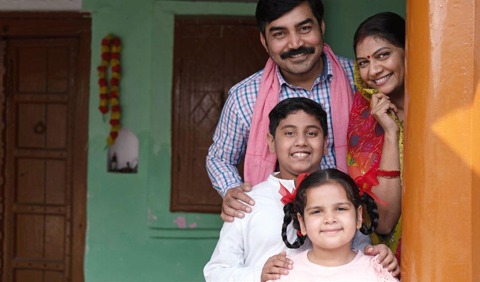 A family at the doorway of their home
